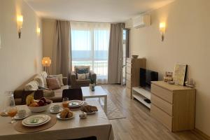 a living room with a couch and a table at Apartments Obzor Beach C - Апартаменти Обзор Бийч С in Obzor
