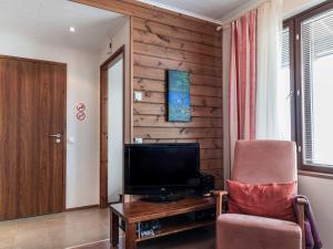 a living room with a television and a chair at Holiday Home Villa ylläs 101 by Interhome in Ylläs