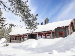 a house covered in snow in front at Holiday Home Lustola a by Interhome in Luosto