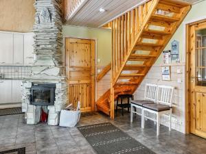 a living room with a staircase and a fireplace at Holiday Home Lustola a by Interhome in Luosto +18 photos