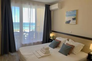 a bedroom with a bed with a view of the ocean at Apartments Obzor Beach C - Апартаменти Обзор Бийч С in Obzor +213 photos