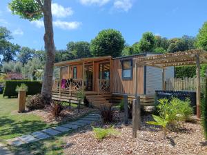 a tiny house in a garden with a pergola at Camping de La Hallerais Dinan in Taden