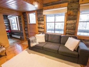 a living room with a couch in a log cabin at Holiday Home Ylläsrova b5 - kasku by Interhome in Ylläsjärvi