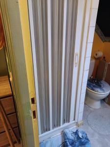 a bathroom with a sliding door with a toilet at Bienvenue in Saint-Pierre-de-Plesguen +36 photos