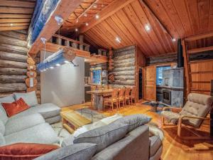 a living room with a couch and a table in a cabin at Holiday Home Karkelo by Interhome in Ylläsjärvi