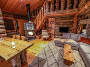 a living room with a couch and a table in a log cabin at Holiday Home Karkelo by Interhome in Ylläsjärvi