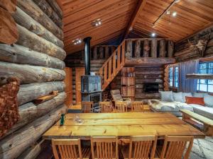 a log cabin living room with a table and a fireplace at Holiday Home Karkelo by Interhome in Ylläsjärvi