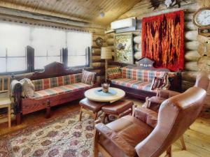 a living room with couches and a table in a cabin at Holiday Home Hankisääski by Interhome in Ylläsjärvi +16 photos
