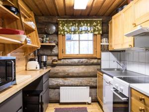 a kitchen with wooden cabinets and a window at Holiday Home Ylläspollu a by Interhome in Ylläsjärvi