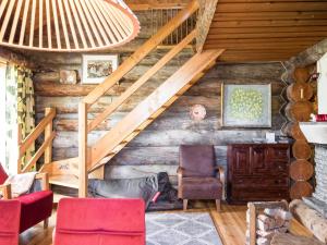 a room with a staircase and chairs in a log cabin at Holiday Home Ylläspollu a by Interhome in Ylläsjärvi