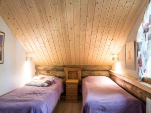 two beds in a room with a wooden ceiling at Holiday Home Ylläspollu a by Interhome in Ylläsjärvi