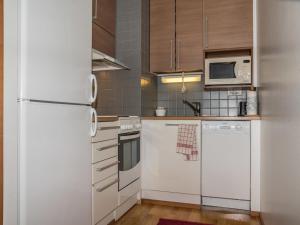 a kitchen with white appliances and wooden cabinets at Holiday Home Ylläs chalets a402 by Interhome in Ylläs +9 photos