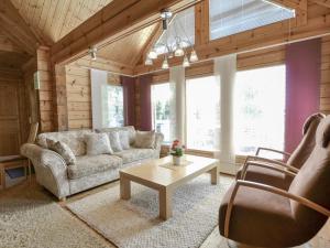 a living room with a couch and a table at Holiday Home Kannelpirtti 2 by Interhome in Puromäki +20 photos