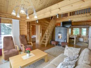 a living room with a couch and a fireplace at Holiday Home Kannelpirtti 2 by Interhome in Puromäki
