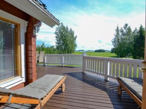 a wooden deck with a bench on a house at Holiday Home Kannelpirtti 2 by Interhome in Puromäki