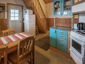 a kitchen with blue cabinets and a table and a stove at Holiday Home Satulinna by Interhome in Matildedal