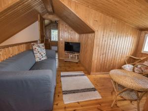 a living room with a blue couch and a television at Holiday Home Satulinna by Interhome in Matildedal +8 photos
