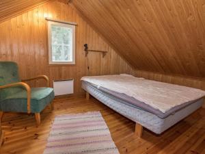 a bedroom with a bed and a chair and a window at Holiday Home Satulinna by Interhome in Matildedal