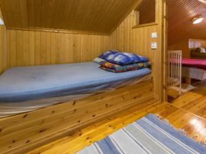 a bed in a wooden room with a bed in a cabin at Holiday Home Meritähti by Interhome in Matildedal +8 photos