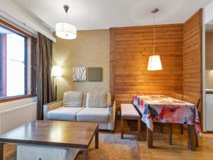 a living room with a table and a couch at Holiday Home Ylläs chalets 2405 by Interhome in Ylläs +8 photos