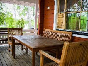 a wooden table and chairs on the porch of a house at Holiday Home Pernoo 1 by Interhome in Pernoo