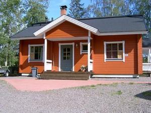 a small orange house with a porch and a door at Holiday Home Pernoo 1 by Interhome in Pernoo