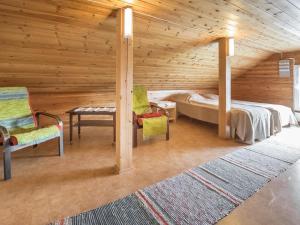 a bedroom with a bed and two chairs and a table at Holiday Home Mäkitupa by Interhome in Laiterla +9 photos