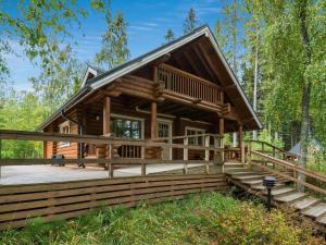 a log cabin with a large deck in the woods at Holiday Home Koivuranta by Interhome in Jämijärvi