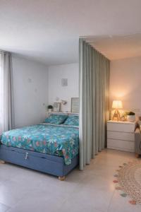 a bedroom with a bed with a blue comforter at Studio Les Salines Orient-Bay in Orient Bay