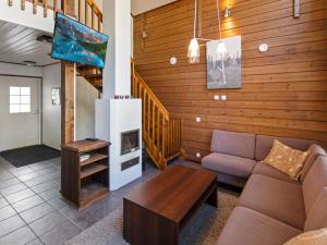 a living room with a couch and a tv at Holiday Home Halla by Interhome in Levi