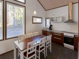 a kitchen with a wooden dining table and chairs at Holiday Home Halla by Interhome in Levi