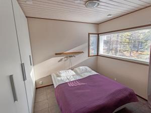 a small bedroom with a purple bed and a window at Holiday Home Halla by Interhome in Levi