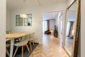 a dining room and living room with a table and chairs at Palau de la Musica Apartments in Barcelona