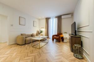 a living room with a couch and a tv at Palau de la Musica Apartments in Barcelona