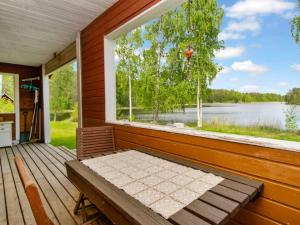 a porch with a bench and a large window at Holiday Home 21 by Interhome in Varparanta +19 photos