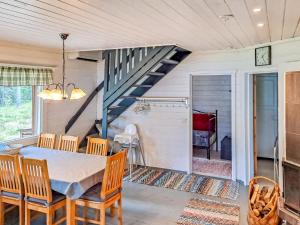 a dining room with a table and chairs and a staircase at Holiday Home Pilkkaniemi by Interhome in Rontsa