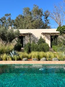 a house with a swimming pool in front of a yard at Maison Flamingo - Boutique hôtel in Essaouira