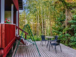 a porch with chairs and a table and a swing at Holiday Home Merimetso 6 by Interhome in Strandby