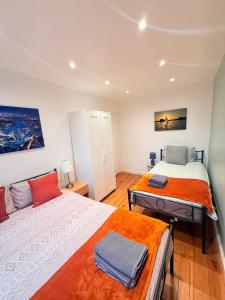 a bedroom with two beds and a painting on the wall at Notting Hill Guest Flat in Ealing