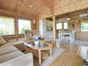 a living room with a couch and a table at Holiday Home Kannelpirtti 1 by Interhome in Puromäki +17 photos