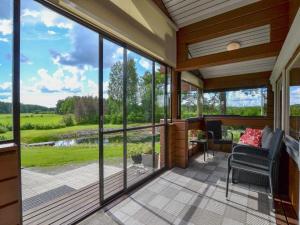 a screened in porch with a view of a field at Holiday Home Kannelpirtti 1 by Interhome in Puromäki