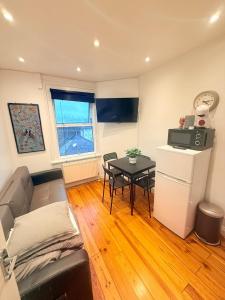 a living room with a couch and a table at Notting Hill Guest Flat in Ealing +25 photos