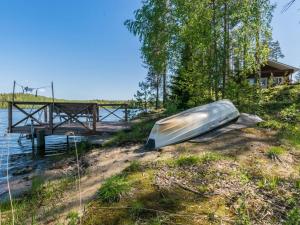a boat sitting on the shore of a body of water at Holiday Home Pajulintu by Interhome in Tiitanvaara +18 photos