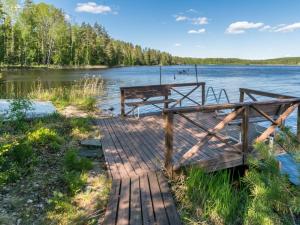 a dock with a picnic table on the shore of a lake at Holiday Home Pajulintu by Interhome in Tiitanvaara