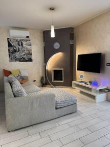 a living room with a couch and a flat screen tv at Casa di Ercolino in Moasca