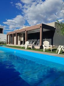 a house with a swimming pool in front of it at Acacias Mina Clavero in Mina Clavero