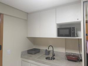 a kitchen with a sink and a microwave at Flat no Vivence Suites em Palmas in Palmas