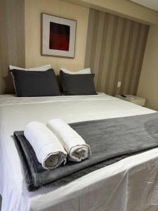 a bedroom with a bed with towels on it at Flat no Vivence Suites em Palmas in Palmas