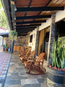 a row of wooden chairs sitting on a patio at Cabañas Tierra Fertil in Montaña