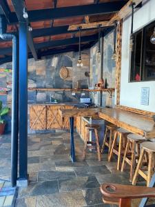 a bar with a wooden table and some chairs at Cabañas Tierra Fertil in Montaña